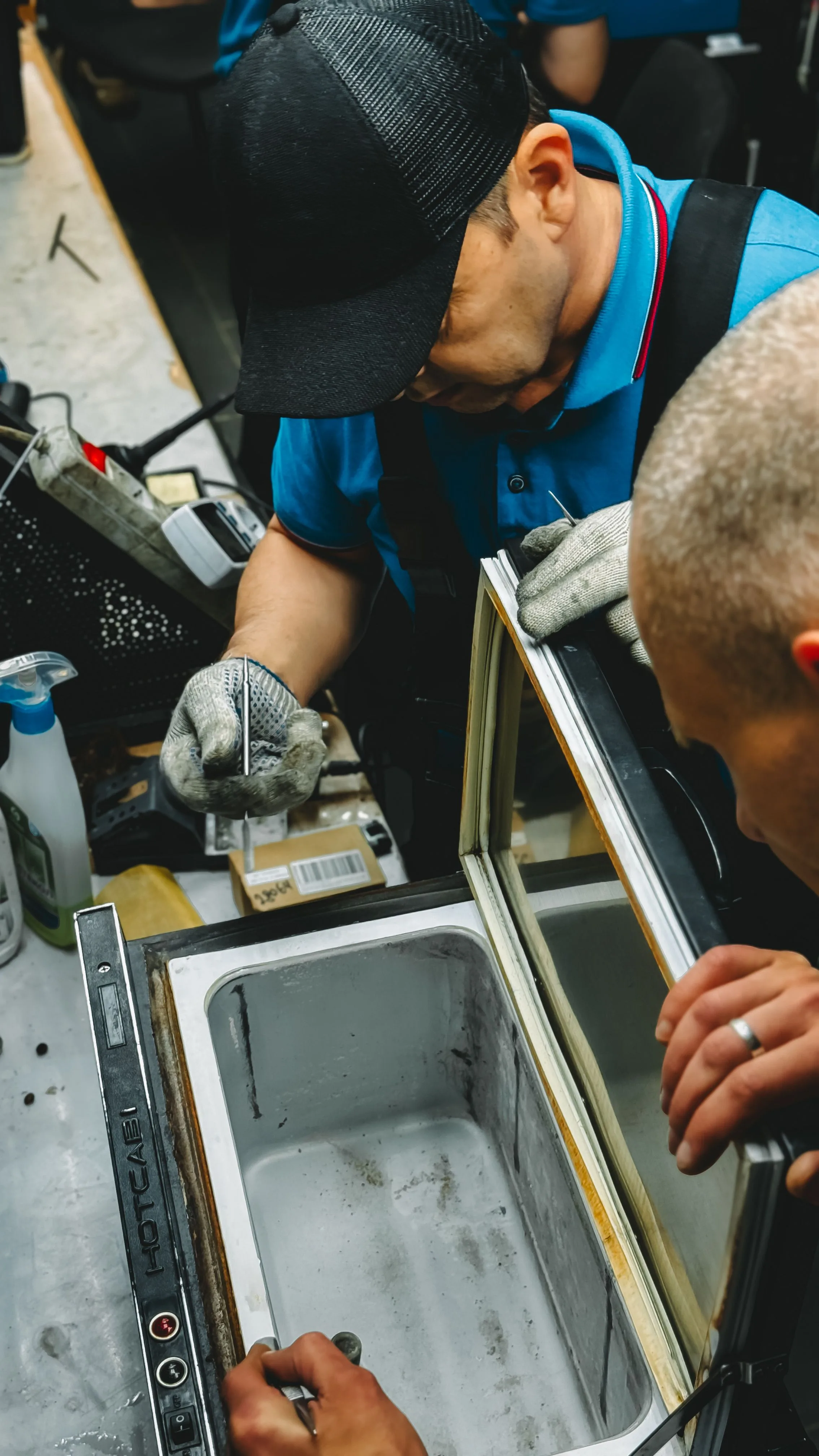 Técnicos realizando reparo em equipamento de refrigeração